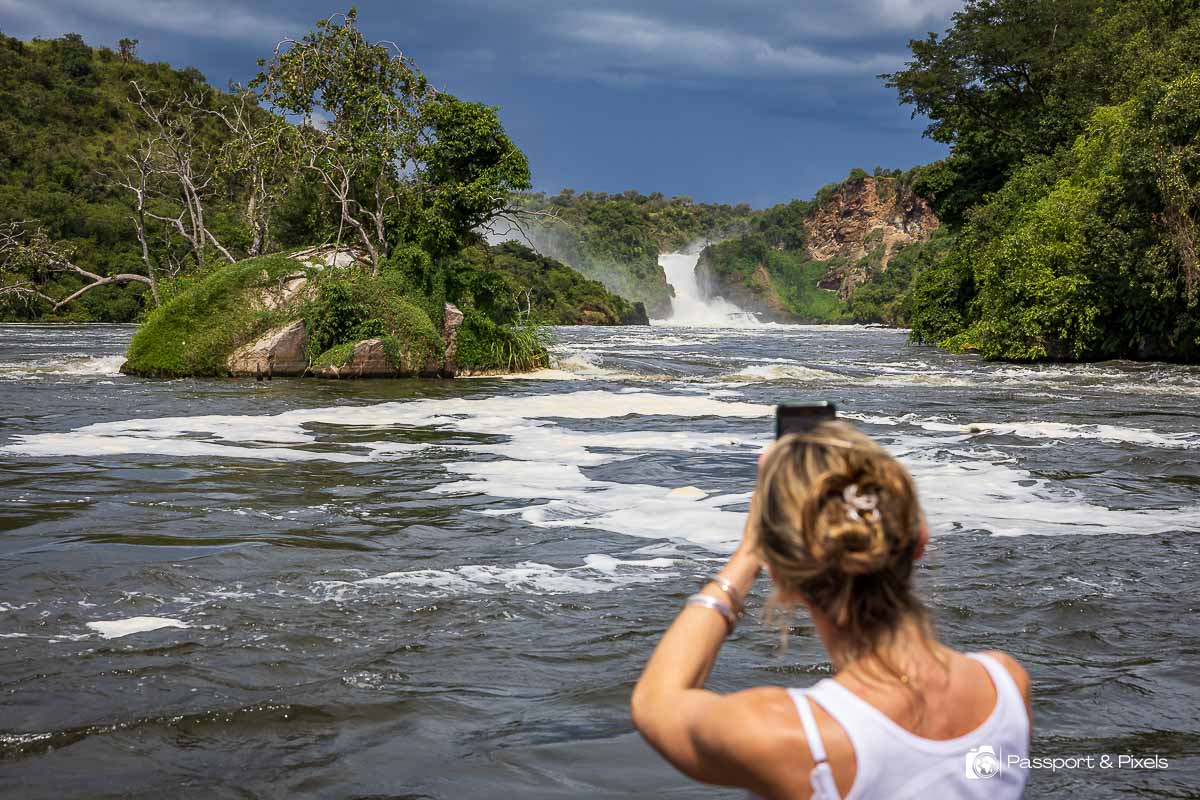 A woman takes a photo of Murchison Falls Uganda