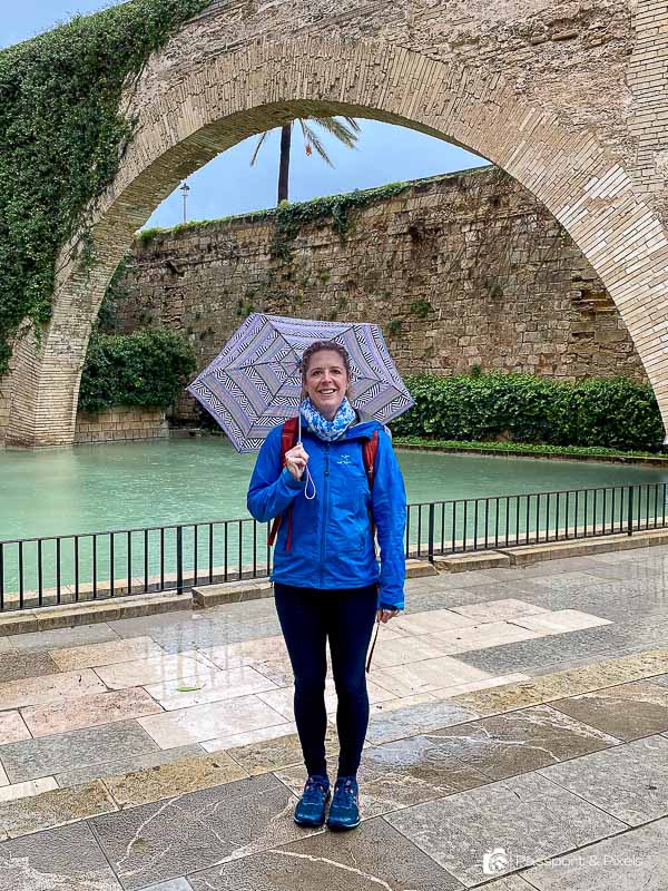 Me, the author, in Palma de Majorca, carrying an umbrella and wearing a blue rain jacket