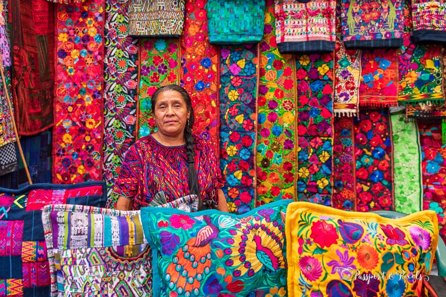 A woman sells colourful embroidered textiles at Chichicastenango market in Guatemala